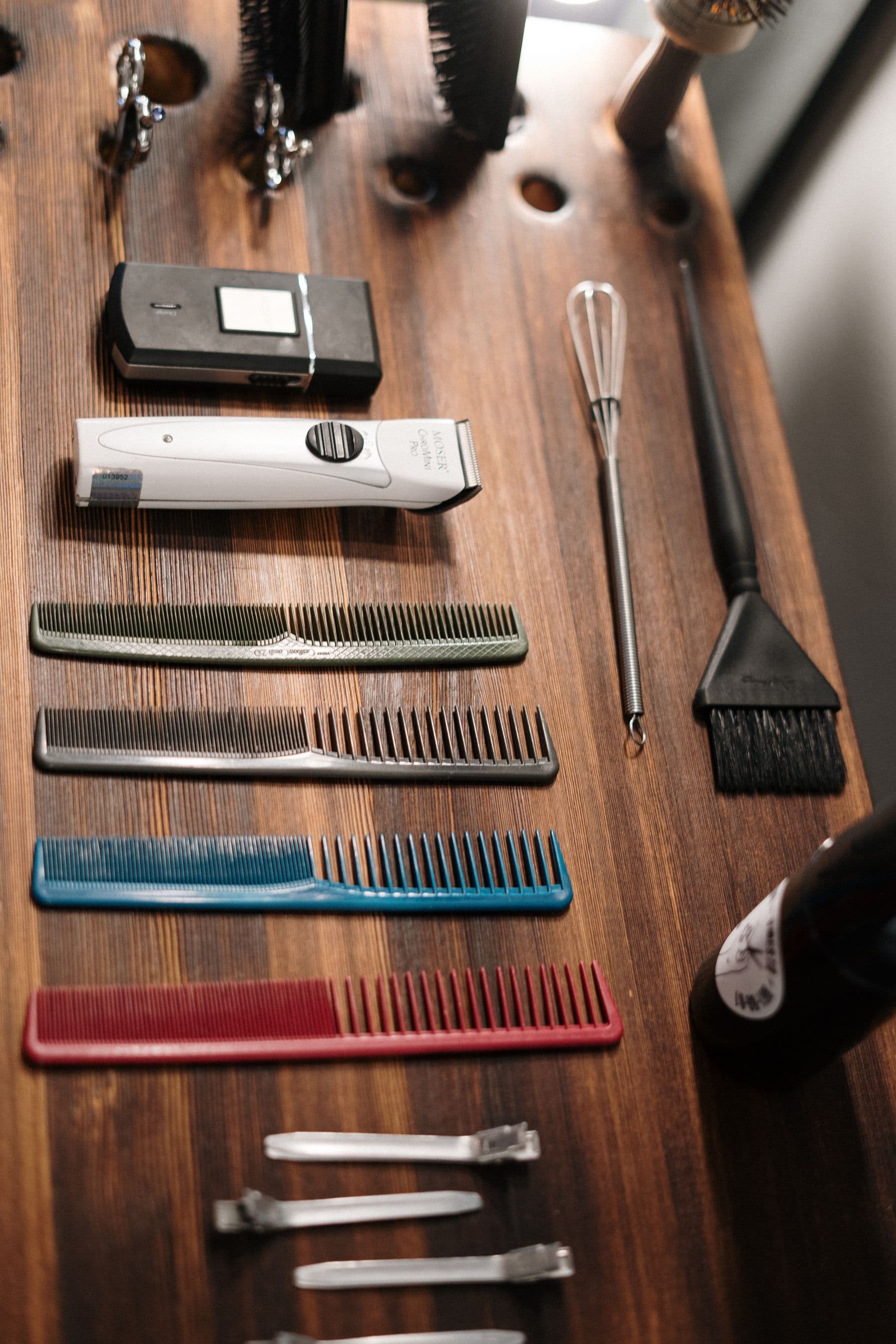 Clippers, combs and brushes on the wooden bench
